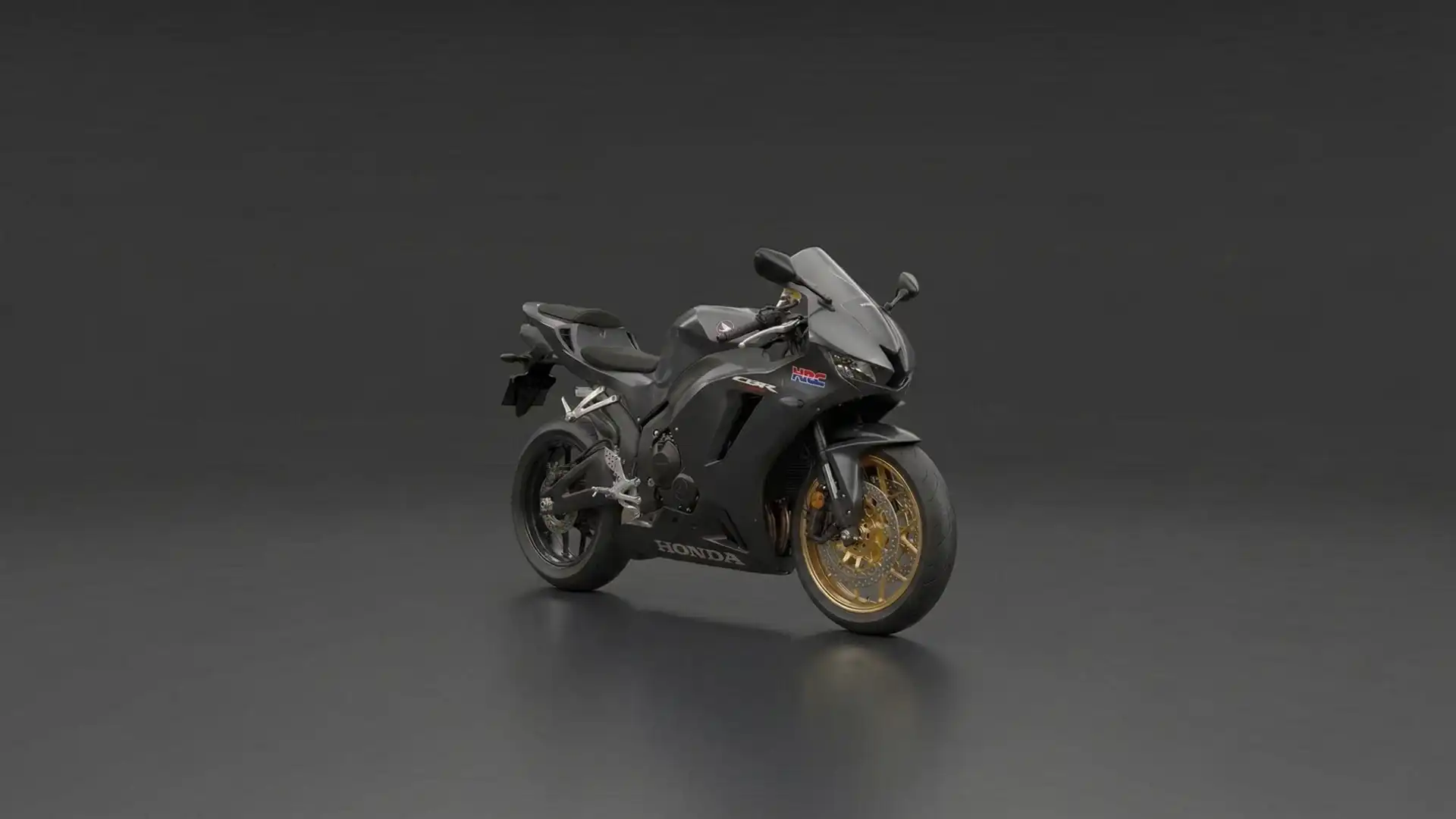 Dreiviertelansicht eines matt-dunkelgrauen Honda CBR Sportmotorrads vor einem neutralen grauen Studiohintergrund. Das goldfarbene Vorderrad bildet einen auffälligen Kontrast.